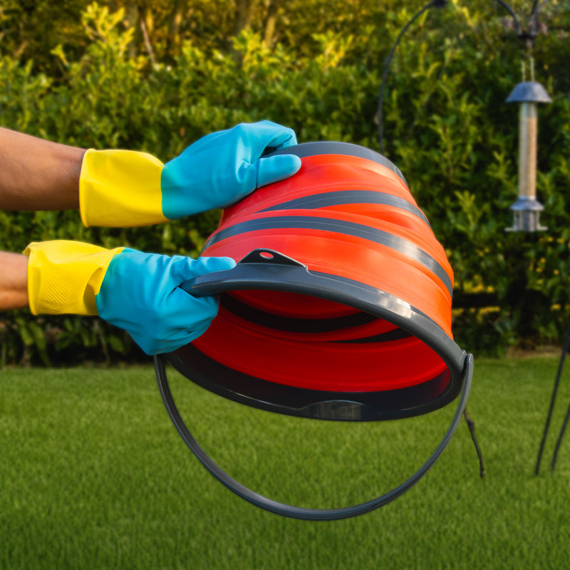 Gloved hands pulling the folding bucket open in the garden