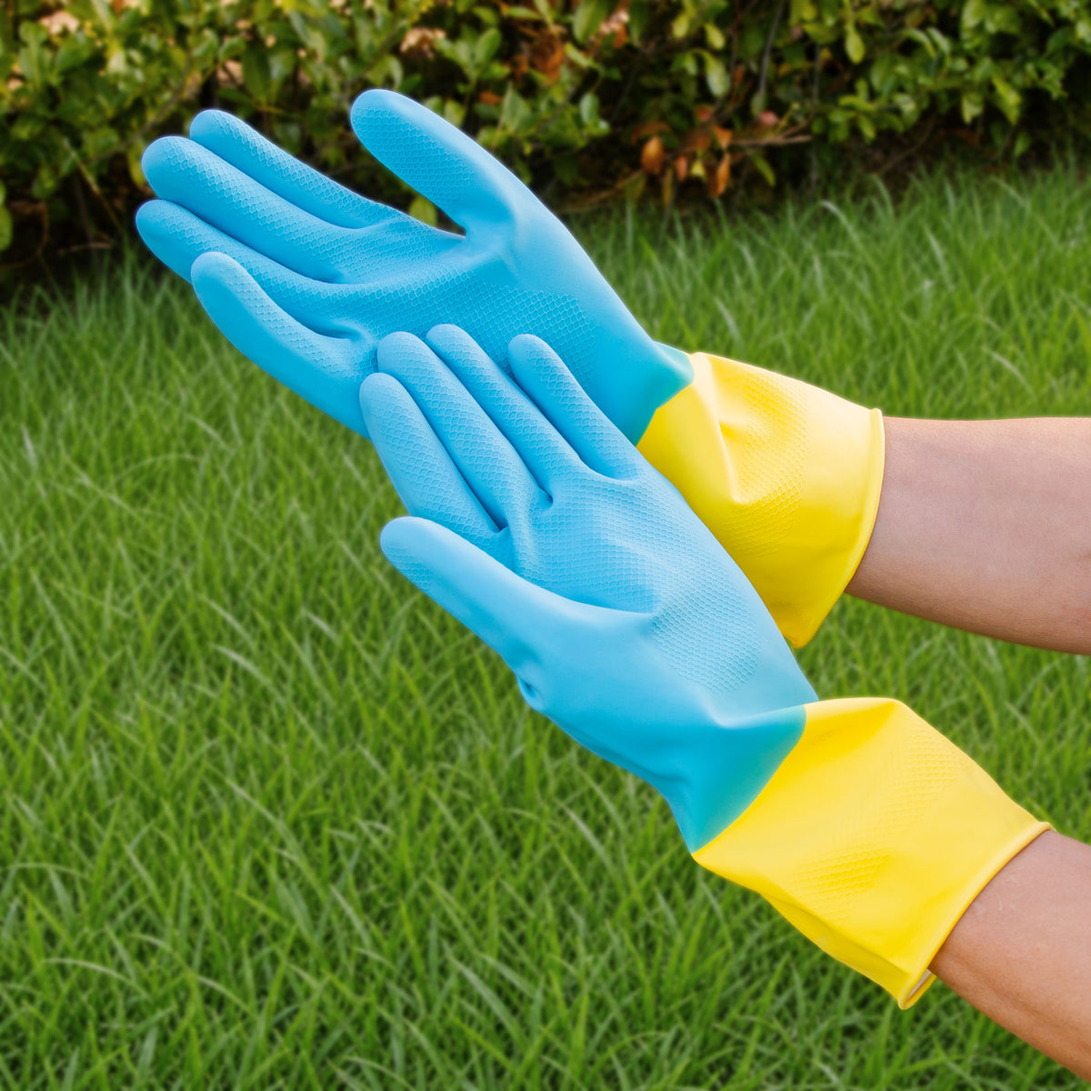 Blue and yellow textured-grip gloves with long cuffs being worn in the garden